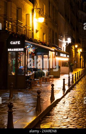 Das Äußere eines traditionellen Cafés am Place Dauphine an der Il de la Cite an einer regnerischen Nacht. Paris Frankreich Stockfoto