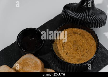 Pastete mit Soße und Croutons auf einem schwarzen Brett Stockfoto