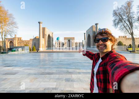 Glücklicher Tourist fotografieren Sie ein Selfie mit Registan in Samarkand, reisen Sie in Usbekistan, Zentralasien Stockfoto