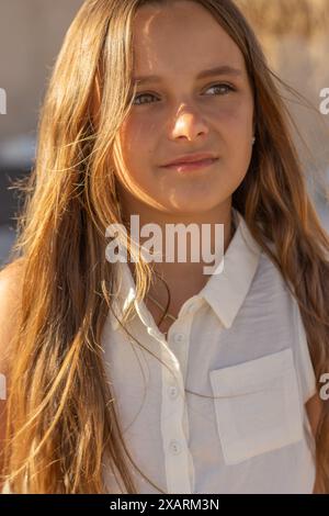 Ein bezauberndes Porträt eines schönen jungen Mädchens mit langen blonden Haaren und leuchtend grünen Augen. Stockfoto