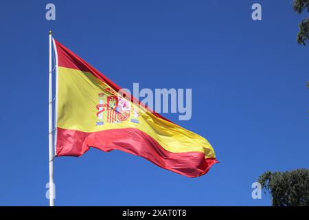 Die spanische Flagge flattert im Wind gegen einen blauen Himmel Stockfoto