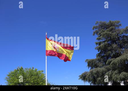 Die spanische Flagge flattert im Wind gegen einen blauen Himmel Stockfoto