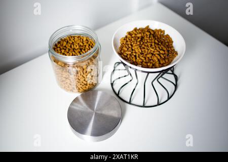 Trockene Katzenfutter in der Schüssel und im Glasbehälter Stockfoto