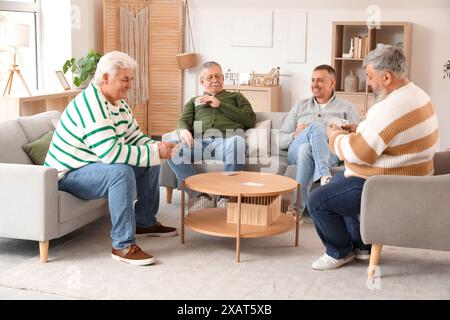 Ältere Männer spielen zu Hause Karten Stockfoto