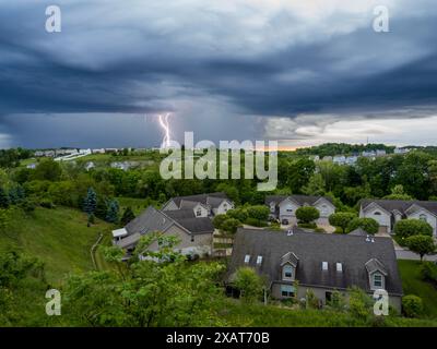 Ein starker Blitz elektrisiert den Abendhimmel über einem US-Viertel Stockfoto