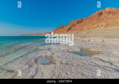 Malerisches Panorama der ruhigen Küste des Toten Meeres in Jordanien mit den mineralreichen Ufern und dem ruhigen blauen Wasser bei Sonnenuntergang von Jordanien Stockfoto