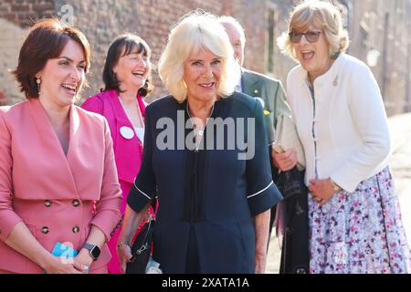 Vicki Perrin (links), CEO des Queen's Reading Room Literary Festival, begrüßt Königin Camilla, die von Fiona Mary Petty-Fitzmaurice, Marchioness of Lansdowne (rechts) begleitet wird, als sie zu einem Empfang mit Autoren, Schauspielern und Literaturliebhabern beim Queen's Reading Room Literary Festival im Hampton Court Palace ankommt. Bilddatum: Samstag, 8. Juni 2024. Stockfoto