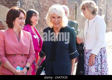 Vicki Perrin (links), CEO des Queen's Reading Room Literary Festival, begrüßt Königin Camilla, die von Fiona Mary Petty-Fitzmaurice, Marchioness of Lansdowne (rechts) begleitet wird, als sie zu einem Empfang mit Autoren, Schauspielern und Literaturliebhabern beim Queen's Reading Room Literary Festival im Hampton Court Palace ankommt. Bilddatum: Samstag, 8. Juni 2024. Stockfoto