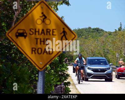 Miami, Florida, USA - 13. April 2024: Warnschild und Fahrräder teilen sich eine Straße mit Autos. Nur für redaktionelle Zwecke. Stockfoto