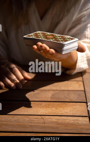 Eine Frau in einem leichten Outfit liest Tarotkarten auf einem Tisch in einem Café Stockfoto