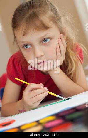 Porträt eines kleinen Mädchens, das drinnen malte Stockfoto