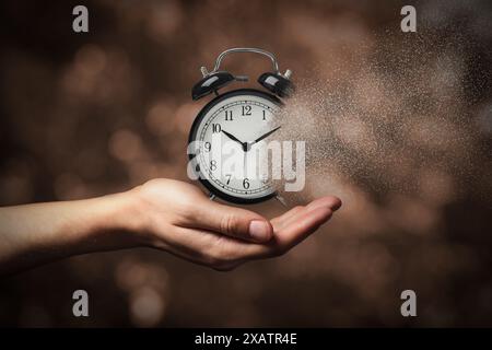 Die Zeit wird knapp. Frau mit auflösendem Wecker auf verschwommenem Hintergrund, Nahaufnahme Stockfoto
