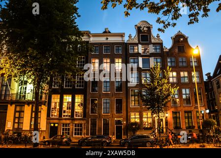 Abendlicher Blick auf die beleuchteten traditionellen Gebäude in Amsterdam Stockfoto