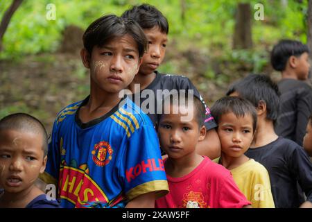 Kinder werden im Flüchtlingslager stehend gesehen. Flüchtlinge aus dem Bürgerkrieg in Myanmar haben in der Nähe der Grenze zu Thailand Zuflucht gefunden. Die Armee Myanmars hat Mörserangriffe und Luftangriffe auf Rebellenpositionen und zivile Siedlungen eingeleitet. Southern Territory Supportive Organization ist eine freiwillige medizinische Team-Organisation, die im August 2021 gegründet wurde. Sie gewährten VERTRIEBENEN, Kriegsflüchtlingen, Wanderarbeitern, revolutionären Kräften und Dörfern unter der Kontrolle der ethnischen Revolutionären Organisation kostenlose medizinische Behandlung. Sie gehen jedes Wochenende an diese Orte. Diese Woche waren sie in Kriegsgeflucht Stockfoto