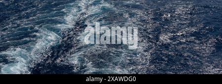 Wellen und Turbulenzen aus der Spur eines Bootes im Meer als Hintergrundstruktur Stockfoto