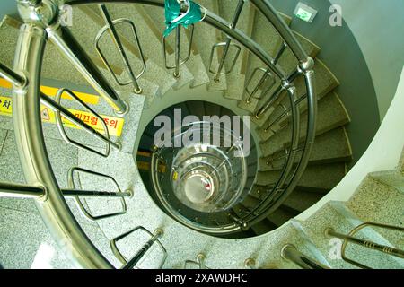 Donghae, Südkorea - 18. Mai 2024: Ein fesselnder Blick über die Wendeltreppe im Mukho Lighthouse. Das spiralförmige Design und das schlanke Metall Stockfoto