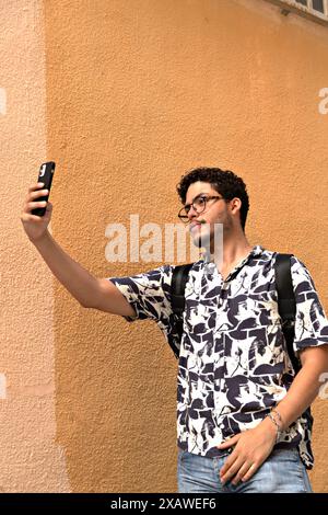 Aktiver Lebensstil: Modern Young man Making Selfie mit seinem Mobile Modern Active Young man macht Selfie mit seinem Handy. Lifestyle, Technologie, Selbstbefriedigung Stockfoto