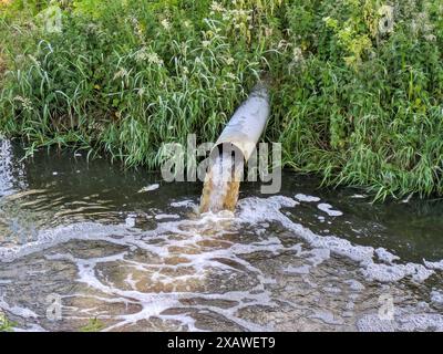 Verschmutzungsabflussrohr in den Fluss Stockfoto