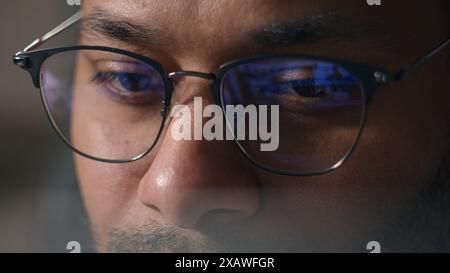 Close-up Geschäftsmann in Brille arbeitet mit Computerdaten Krypto Analyse zugeschnittene Ansicht männliche Augen in Brille Blick auf Laptop Monitor blau Stockfoto