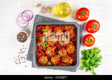 Hausgemachte Spaghetti mit Tomatensoße, Fleischklößchen und Gewürzen, serviert auf grauer Platte auf schwarzem Schieferhintergrund. Leckere gekochte Pasta mit Hackfleisch/Rinderfleisch Stockfoto