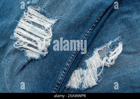 Nahaufnahme mit Loch in Jeans. Textur von verblasstem Denim Stockfoto