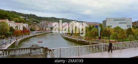 Bilbao, Spanien - 3. Oktober 2024; Touristen gehen über eine Brücke im Regen Stockfoto