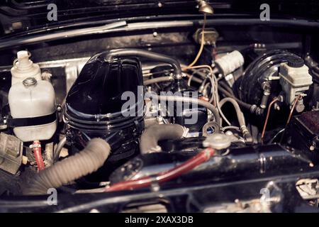 Detailansicht eines alten Oldtimer-Motors mit verschiedenen Teilen und Verkabelung unter der Motorhaube Stockfoto