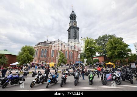 Hamburg, Deutschland. Juni 2024. Motorradpark an der Ludwig-Erhard-Straße vor der Hauptkirche St. Michaelis (Michel) während des 41. Hamburger Motorradservice (Mogo). Der Verein Mogo Hamburg in der Nordkirche e.V. organisiert den angeblich größten Motorradservice Europas. Quelle: Georg Wendt/dpa/Alamy Live News Stockfoto