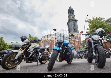 Hamburg, Deutschland. Juni 2024. Motorradpark an der Ludwig-Erhard-Straße vor der Hauptkirche St. Michaelis (Michel) während des 41. Hamburger Motorradservice (Mogo). Der Verein Mogo Hamburg in der Nordkirche e.V. organisiert den angeblich größten Motorradservice Europas. Quelle: Georg Wendt/dpa/Alamy Live News Stockfoto