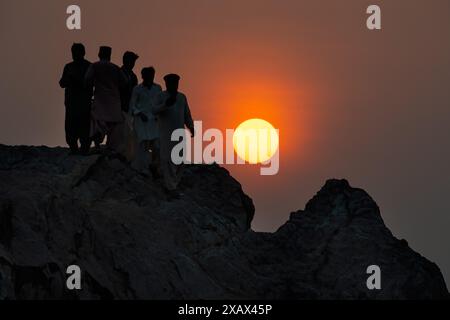 Silhouette Gruppe von Freunden auf Gadani Rock Sonnenuntergang Zeit. EID Urlaub Stockfoto