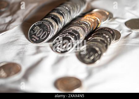 Nahaufnahme indonesischer Rupiah-Münzen in verschiedenen Stückelungen auf weißer Oberfläche. Stockfoto