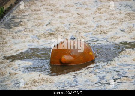 Der Helm eines Tauchers blickt aus einem Pool in einer Kläranlage Stockfoto