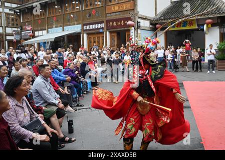 (240609) -- PEKING, 9. Juni 2024 (Xinhua) -- Touristen genießen die gesichtsverändernde Vorstellung der Sichuan Oper in Neijiang, südwestchinesische Provinz Sichuan, 9. Juni 2024. Die Menschen genießen den 3-tägigen Feiertag des Dragon Boat Festival, auch Duanwu Festival genannt, das am 10. Juni dieses Jahres stattfindet, über verschiedene Aktivitäten im ganzen Land. (Foto: Tang Mingrun/Xinhua) Stockfoto