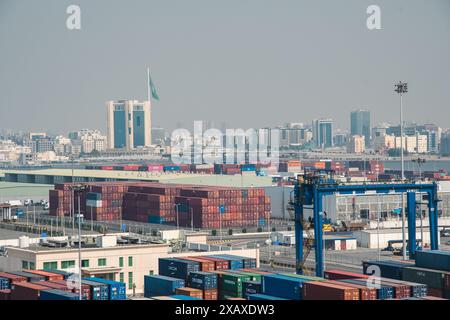 Jeddah, Saudi-Arabien - 12. Dezember 2022: Eine geschäftige Hafenszene mit gestapelten Containern, die die Skyline von Jeddah im Vordergrund stehen. Stockfoto