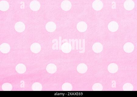 Nahaufnahme der Textur eines rosafarbenen Papiers mit weißen Polka Dots. Als Hintergründe, Hintergrundbilder und Texturen verwenden. Horizontal. Stockfoto