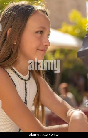 Dieses Foto zeigt ein schönes Mädchen mit langen blonden Haaren und leuchtend grünen Augen, das für ein Porträt posiert. Stockfoto