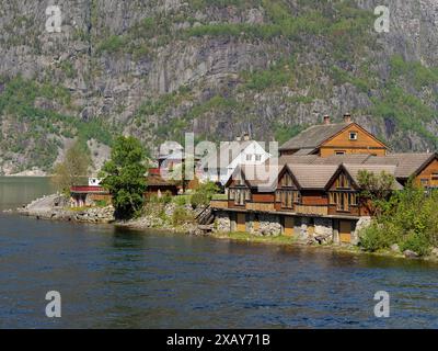 Gemütliche Holzhütten am Ufer eines Sees umgeben von Bergen, ruhige und friedliche Atmosphäre, eidfjord, norwegen Stockfoto