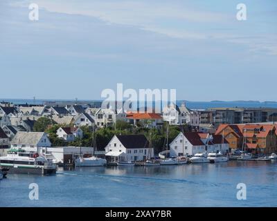 Hafenstadt mit modernen und traditionellen Häusern entlang der Küste, Booten im Wasser und einem weiten Blick über das Meer, Haugesund, Norwegen Stockfoto