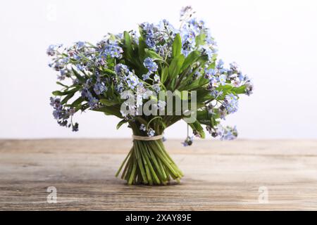 Blumenstrauß mit wunderschönen Vergissmeinsblumen auf Holztisch vor weißem Hintergrund Stockfoto