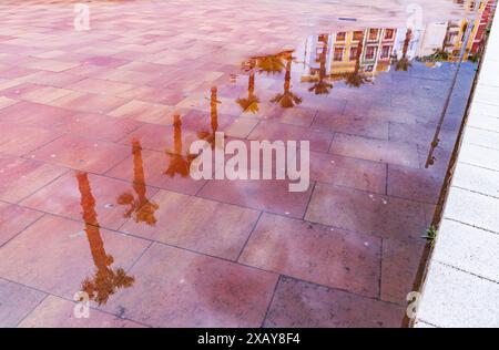 Reflexionen der Häuser in den Pfützen an der Strandpromenade in Villajoyosa Stockfoto