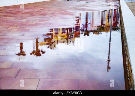 Reflexionen der Häuser in den Pfützen an der Strandpromenade in Villajoyosa Stockfoto