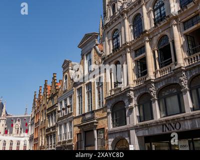 Reihe historischer Gebäude mit detaillierten Fassaden und Fenstern im Stadtzentrum bei klarem Sommerwetter, Brügge, Belgien Stockfoto