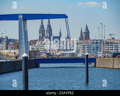 Hafenblick mit modernen Gebäuden, Brücke im Vordergrund und historischen Kathedralen im Hintergrund, oostende, Belgien Stockfoto