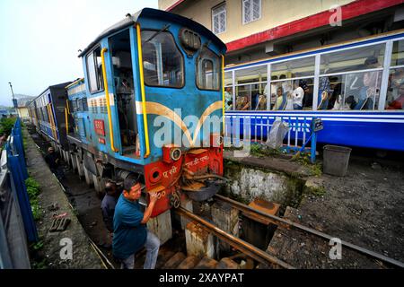 Ein Eisenbahnmitarbeiter sah, wie er an einer Toy Train-Dampflok am Bahnhof Darjeeling arbeitete. Die Darjeeling Himalayan Railway, auch bekannt als „Toy Train“, ist ein Schmalspurzug und wurde zwischen 1879 und 1881 gebaut. Die Bahn bewegt sich auf eine Höhe von 2.200 Metern (7.218 ft). Vier moderne Diesellokomotiven übernehmen den Großteil des Linienverkehrs; die täglichen Touristenzüge von Darjeeling nach Ghum (dem höchsten Bahnhof Indiens) werden jedoch von den alten Dampflokomotiven der B-Klasse abgewickelt. DHR wurde 1999 von der UNESCO zum Weltkulturerbe erklärt. (Foto von Avishek Stockfoto