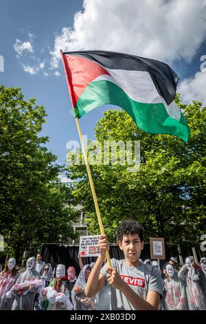 Rotterdam, Süd-Holland, Niederlande. Juni 2024. Ein junger Demonstrant schwingt eine palästinensische Flagge vor einer Gruppe von Demonstranten. Am 9. Juni 2024 marschierten pro-palästinensische Demonstranten, die gegen die jüngsten Maßnahmen und die Gewalt Israels in Rafah protestierten, durch Rotterdam in den Niederlanden. (Kreditbild: © James Petermeier/ZUMA Press Wire) NUR REDAKTIONELLE VERWENDUNG! Nicht für kommerzielle ZWECKE! Stockfoto