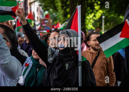 Rotterdam, Süd-Holland, Niederlande. Juni 2024. Eine Frau, deren Mund verschlossen ist, gibt ein Friedenszeichen. Am 9. Juni 2024 marschierten pro-palästinensische Demonstranten, die gegen die jüngsten Maßnahmen und die Gewalt Israels in Rafah protestierten, durch Rotterdam in den Niederlanden. (Kreditbild: © James Petermeier/ZUMA Press Wire) NUR REDAKTIONELLE VERWENDUNG! Nicht für kommerzielle ZWECKE! Stockfoto