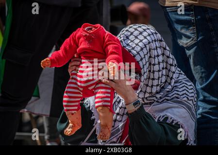 Rotterdam, Süd-Holland, Niederlande. Juni 2024. Eine Frau hält eine Schaufensterpuppe eines enthaupteten Kindes - symbolisiert die Kinder, die in Gaza getötet wurden. Am 9. Juni 2024 marschierten pro-palästinensische Demonstranten, die gegen die jüngsten Maßnahmen und die Gewalt Israels in Rafah protestierten, durch Rotterdam in den Niederlanden. (Kreditbild: © James Petermeier/ZUMA Press Wire) NUR REDAKTIONELLE VERWENDUNG! Nicht für kommerzielle ZWECKE! Stockfoto