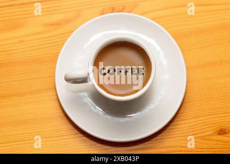 Espresso-Kaffee in einer kleinen Keramiktasse mit Text auf der Oberseite Stockfoto
