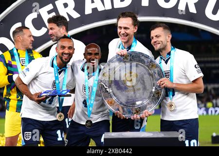 Der englische Theo Walcott (links), Sir Mo Farah, Tom Hiddleston und Jack Wilshere (rechts) mit der Trophäe nach dem Sieg in der Soccer Aid für UNICEF 2024 auf der Stamford Bridge, London. Bilddatum: Sonntag, 9. Juni 2024. Stockfoto