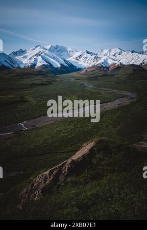 Bewundern Sie die schneebedeckten Berge Alaskas und einen sich windenden Fluss durch üppige Täler. Ideal für Themen wie Natur, Abenteuer und Gelassenheit, mit Einem Stockfoto